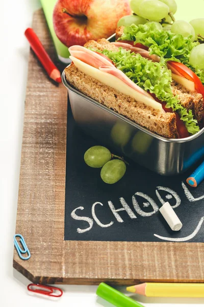 Lunch box with sandwich and fruits on chalk board — Stock Photo, Image