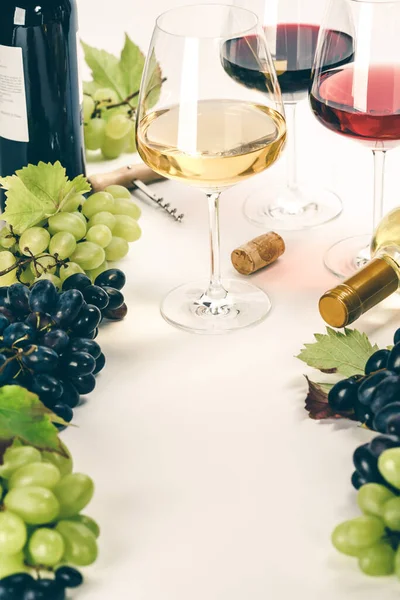 Szklanki białego, czerwonego i różanego wina i winogron — Zdjęcie stockowe