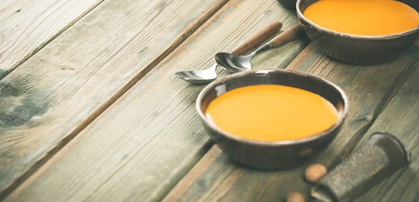 Pumpkin soup in bowls on wooden table, space for text — Stock Photo, Image