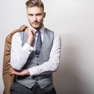 Elinde uzun şık ceket ile zarif genç yakışıklı adam. 