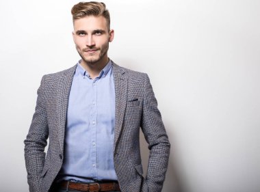 Zarif yakışıklı genç gri ceketli poz studio arka planı. 