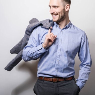 Ceket ile mavi tişörtlü zarif genç yakışıklı adam. Studio moda portre. 