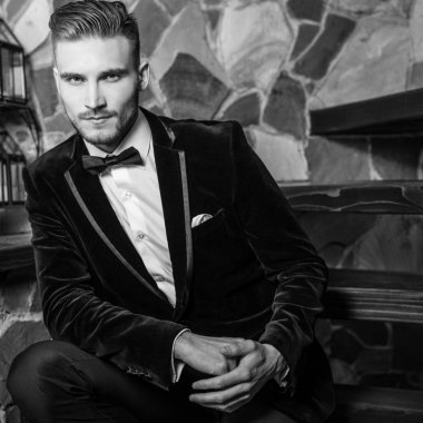 Zarif yakışıklı genç poz ev iç karşı. Siyah-beyaz portre.