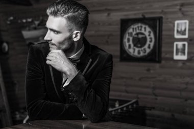 Zarif yakışıklı genç poz ev iç karşı. Siyah-beyaz portre.