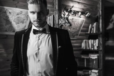 Zarif yakışıklı genç poz ev iç karşı. Siyah-beyaz portre.