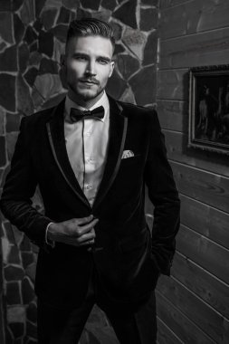 Zarif yakışıklı genç poz ev iç karşı. Siyah-beyaz portre.