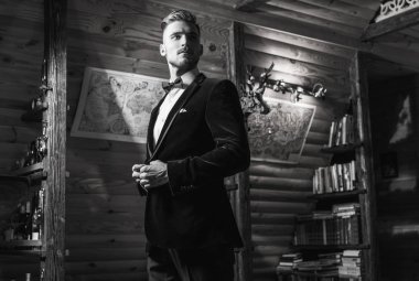 Zarif yakışıklı genç poz ev iç karşı. Siyah-beyaz portre.