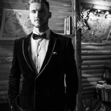 Zarif yakışıklı genç poz ev iç karşı. Siyah-beyaz portre.