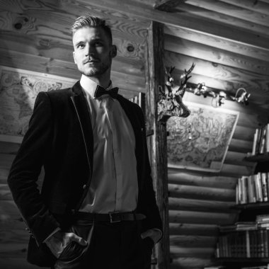 Zarif yakışıklı genç poz ev iç karşı. Siyah-beyaz portre.