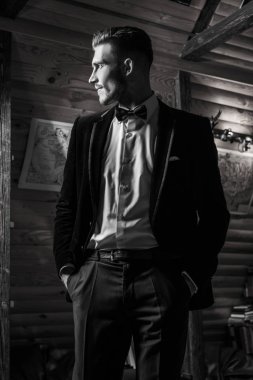 Zarif yakışıklı genç poz ev iç karşı. Siyah-beyaz portre.