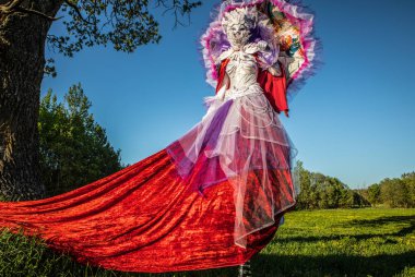 Fairy tale woman on stilts in bright fantasy stylization. Fine art outdoor photo.  clipart
