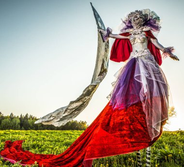 Peri masalı kadın parlak fantastik filmde gümüş bayrağı ile stilts. Güzel Sanatlar açık fotoğraf. 