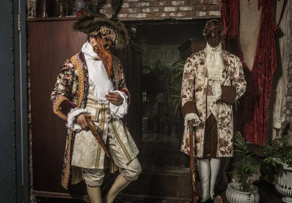 Actors in steam punk masks and antique costumes indoor.