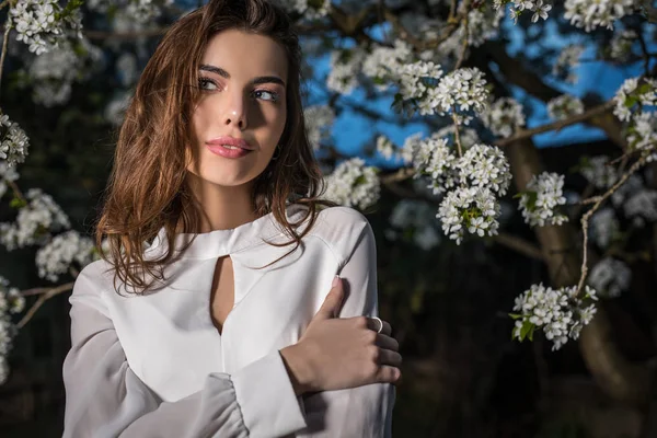 美丽的年轻女子画像在秋季花园反对盛开的樱桃的白色礼服 — 图库照片