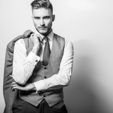 Elinde uzun şık ceket ile zarif genç yakışıklı adam. 