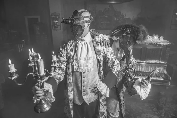 Actors in steam punk masks and antique costumes black-white art photo.