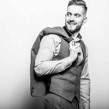 Zarif yakışıklı genç gri klasik yelek içinde poz studio arka planı.