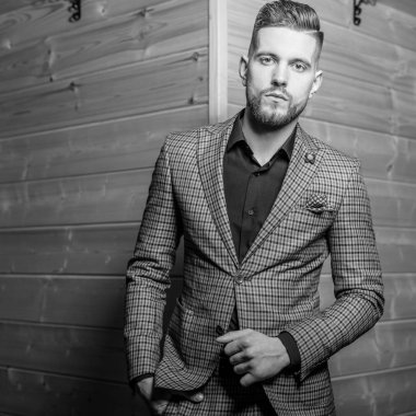 Zarif yakışıklı genç poz ahşap arka plan karşı. Siyah-beyaz fotoğraf.