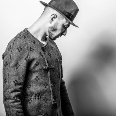 Şık yakışıklı genç uzun palto ve şapka. Siyah-beyaz fotoğraf.