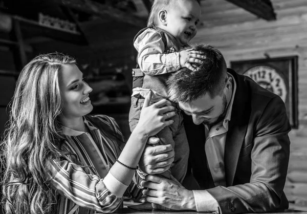 Genç mutlu aile birlikte iç ahşap ev. Siyah-beyaz portre.