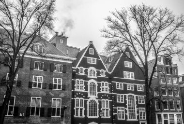 Amsterdam, Hollanda - 28 Aralık 2016: Ünlü binalar ve güneş, Amsterdam şehir merkezinin yer saatini ayarlayın. Genel manzara görünümü. 28 Aralık 2016 - Amsterdam - Hollanda
