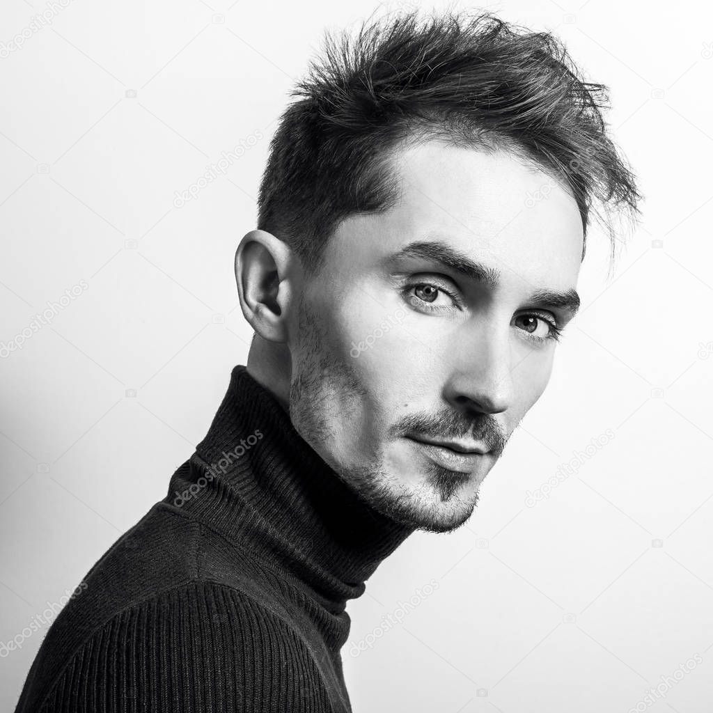 Handsome young elegant man in golf. Black-white studio photo.