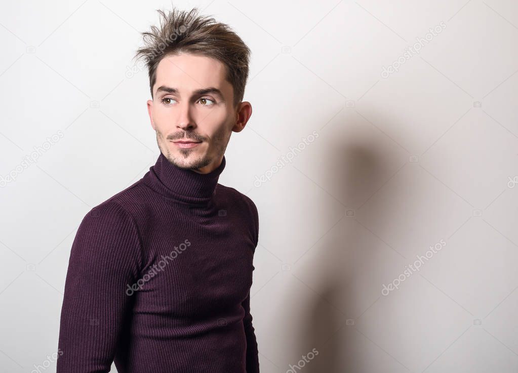 Handsome young elegant man in violet golf.