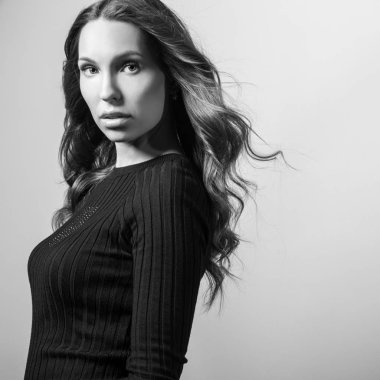 Stüdyoda poz şık siyah elbise güzel kız. Siyah-beyaz portre.