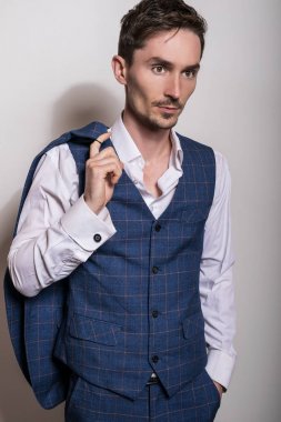 Beyaz gömlek ve yelek zarif genç yakışıklı adam. Stüdyo moda portre.
