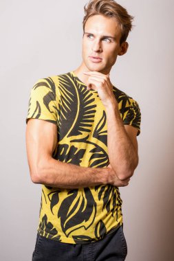 Sarı tişört zarif genç yakışıklı adam. Stüdyo portre.