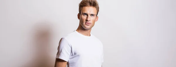 优雅的年轻帅哥在白色T恤 工作室肖像 — 图库照片
