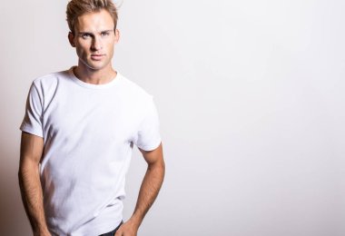 Beyaz tişört zarif genç yakışıklı adam. Stüdyo portre.