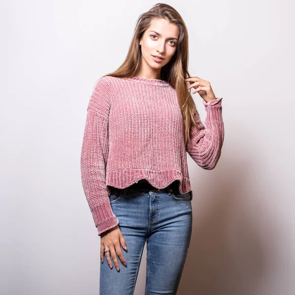 Young model woman in sweater pose in studio.