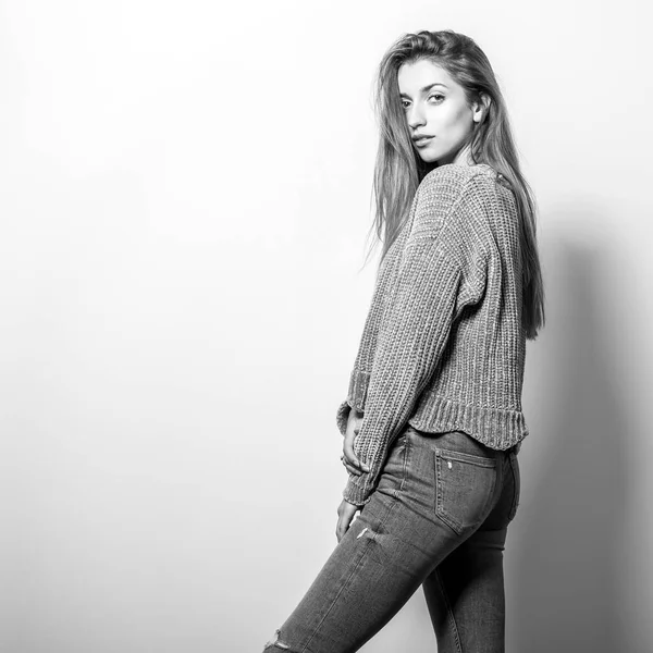 Young model woman in sweater pose in studio. Black-white photo.