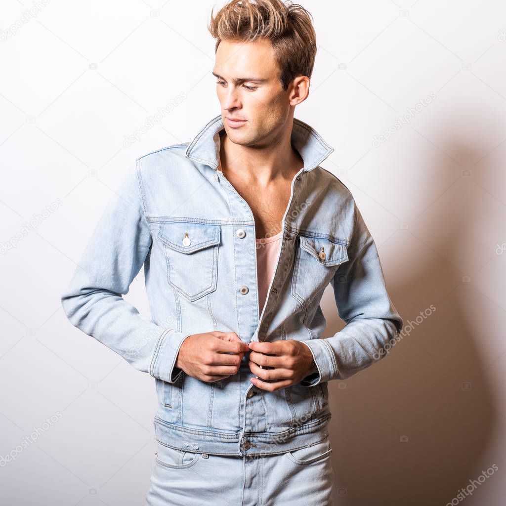 Handsome young man in jeans jacket pose in studio.