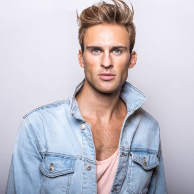 Kot ceket yakışıklı genç adam stüdyoda poz.