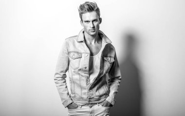 Kot ceketli yakışıklı genç adam. Siyah-beyaz stüdyo portresi.