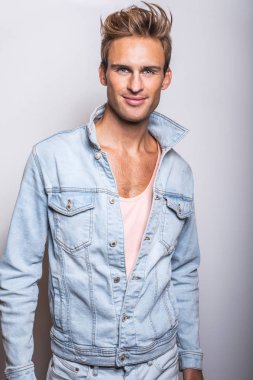 Kot ceket yakışıklı genç adam stüdyoda poz.