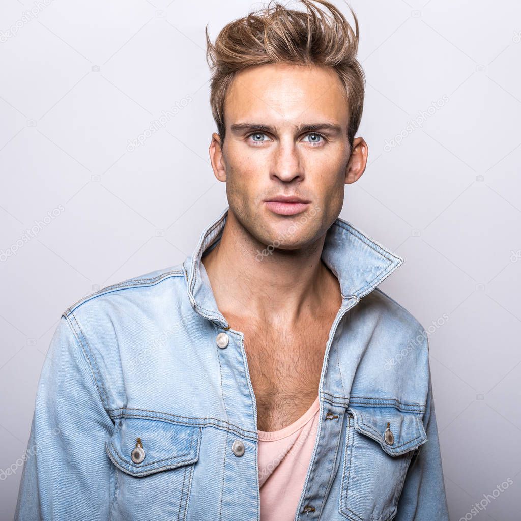 Handsome young man in jeans jacket pose in studio.
