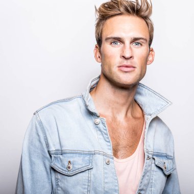 Kot ceket yakışıklı genç adam stüdyoda poz.