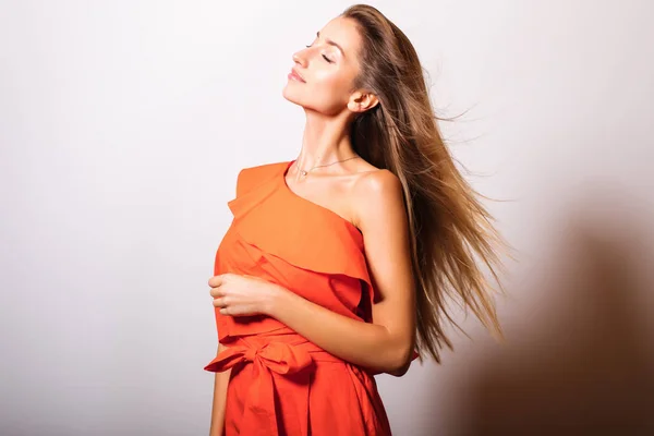 Turuncu Elbiseli Genç Manken Kadın Stüdyoda Poz Veriyor — Stok fotoğraf