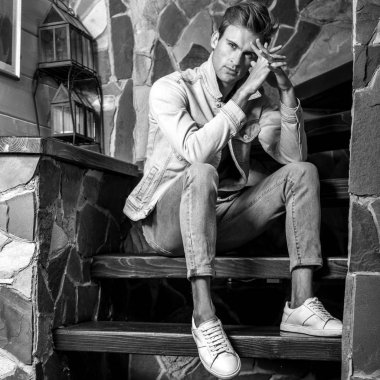 Doğal taş arka plan karşı genç yakışıklı erkek modeli. Siyah-beyaz portre.