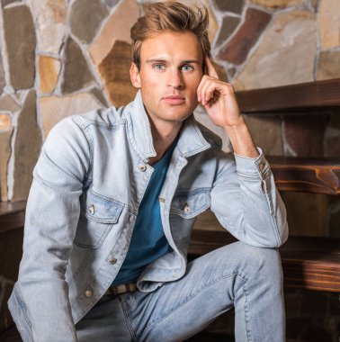 Doğal taş arka plan karşı genç yakışıklı erkek modeli.