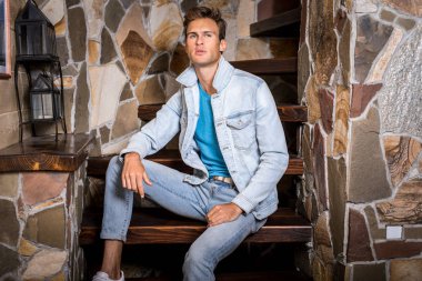 Doğal taş arka plan karşı genç yakışıklı erkek modeli.