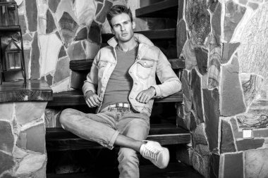 Doğal taş arka plan karşı genç yakışıklı erkek modeli. Siyah-beyaz portre.