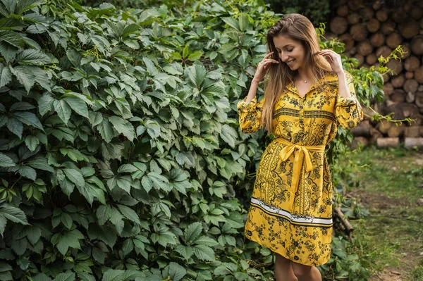 黄色のドレスを着た若い女性の美しい感情的な屋外の肖像画 — ストック写真
