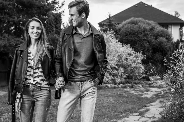 Young beautiful couple in garden near house. Black-white photo.