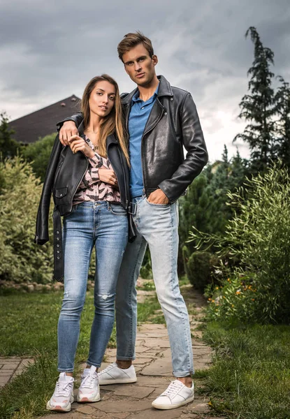 Young beautiful couple in garden near house.