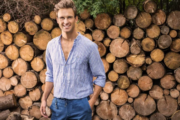 年轻的英俊男子在休闲衬衫姿势接近木制背景 — 图库照片