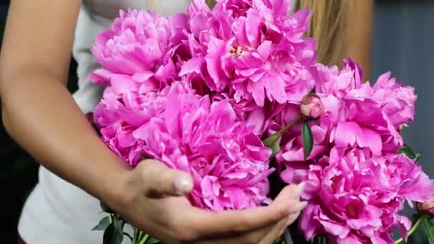 Tangan wanita cantik mengumpulkan karangan bunga peonies merah muda. 4K rekaman. — Stok Video